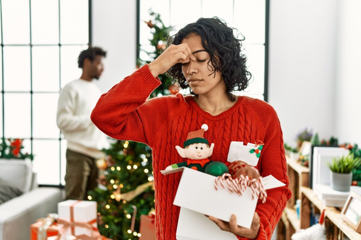 Woman holding her head because of a headache caused by holiday stress
